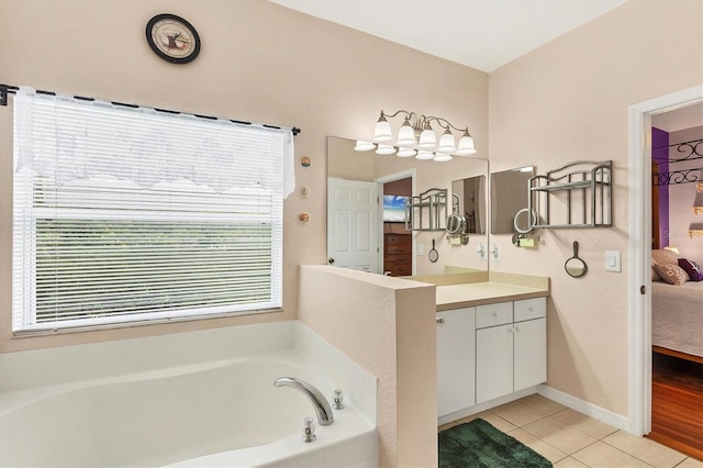 bathroom with a washtub, vanity, and tile patterned floors