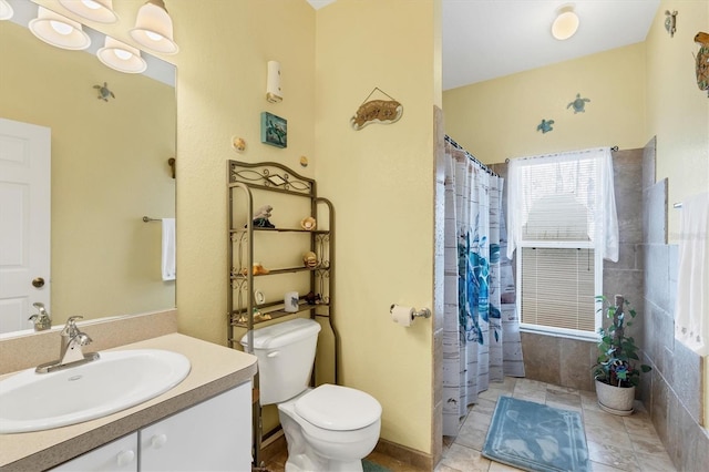 bathroom featuring walk in shower, vanity, toilet, and tile patterned flooring