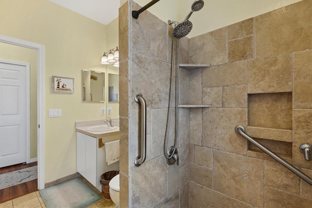 bathroom with tile patterned flooring, vanity, and a tile shower