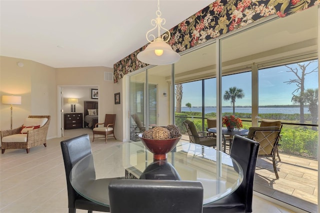 tiled dining area featuring a water view