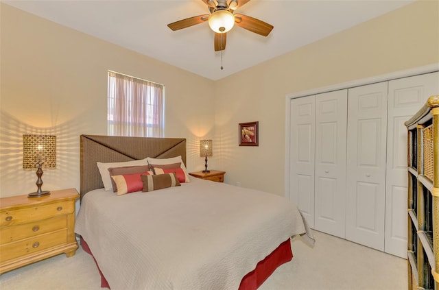 bedroom featuring light carpet, ceiling fan, and a closet