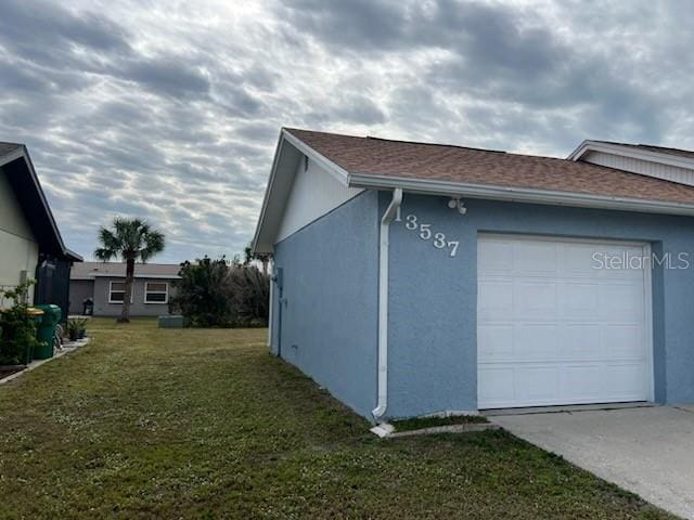 view of home's exterior featuring a garage and a lawn