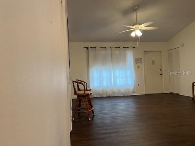 spare room with a ceiling fan and dark wood-style flooring