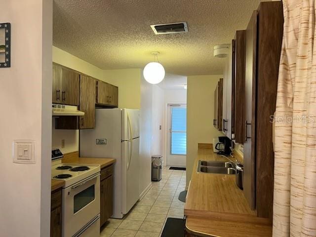 kitchen with white electric stove, visible vents, light countertops, light tile patterned flooring, and under cabinet range hood