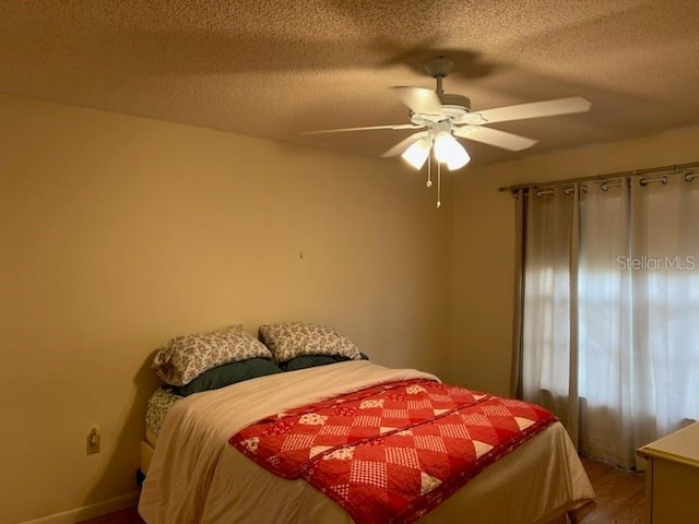 bedroom featuring a textured ceiling, ceiling fan, and wood finished floors