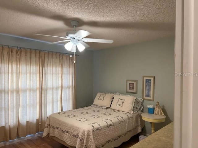 bedroom with ceiling fan and a textured ceiling