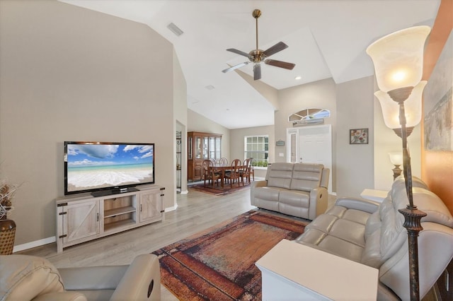 living room with ceiling fan, lofted ceiling, and light hardwood / wood-style floors