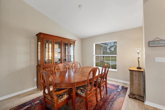 dining room with lofted ceiling and light hardwood / wood-style floors