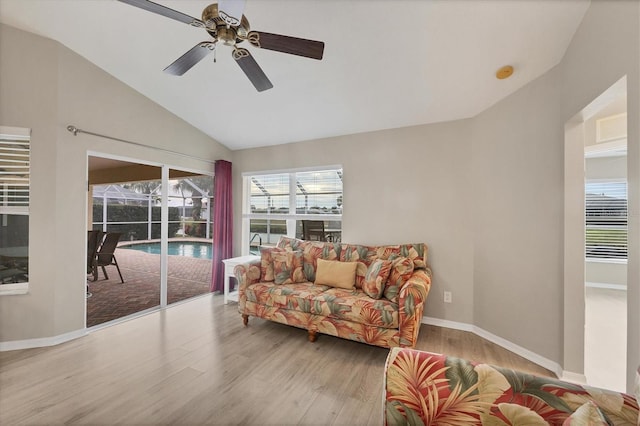 living room with ceiling fan, light hardwood / wood-style flooring, and lofted ceiling