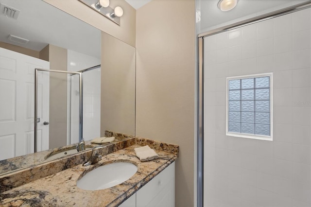 bathroom with vanity and a shower with door