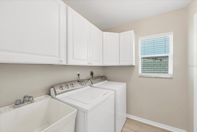 laundry area with cabinets, sink, independent washer and dryer, and light wood-type flooring