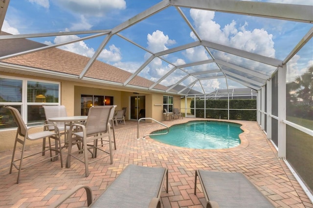 view of pool with a patio area and glass enclosure