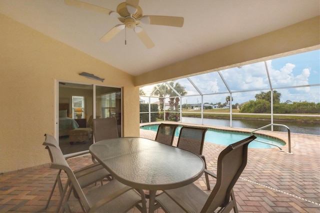 exterior space with a water view, glass enclosure, and a patio