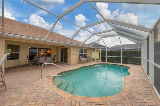 view of swimming pool with glass enclosure and a patio area