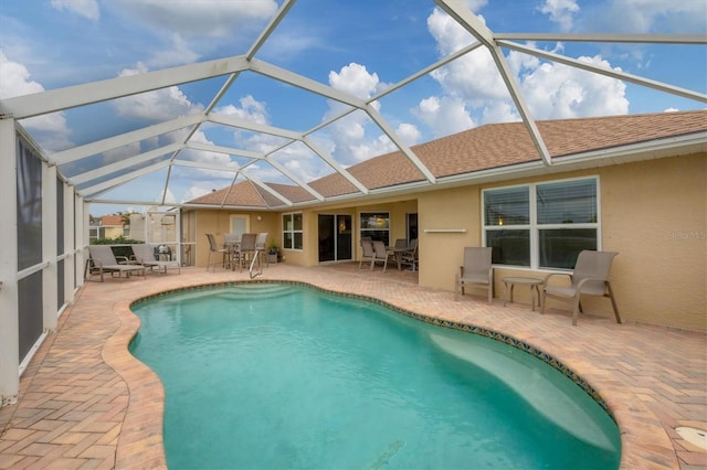 view of pool featuring glass enclosure and a patio