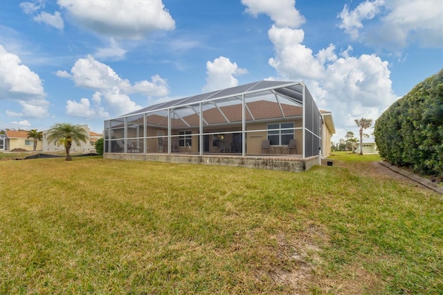 rear view of property with a lanai and a yard