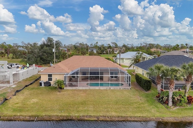 back of property featuring glass enclosure, a fenced in pool, a lawn, and a water view