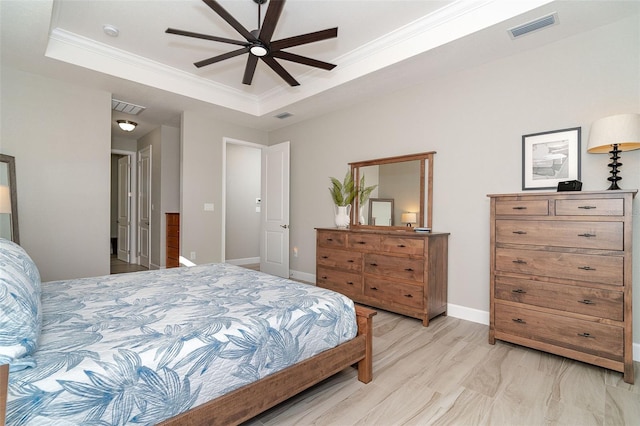 bedroom with a raised ceiling, ceiling fan, light wood-type flooring, and crown molding