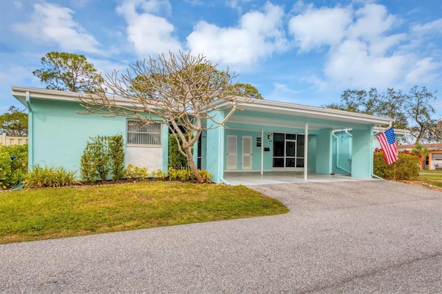 view of front of home with a carport and a front yard