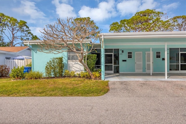 view of front of property with a front lawn and a carport