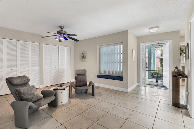 sitting room featuring ceiling fan, a textured ceiling, and light tile patterned floors