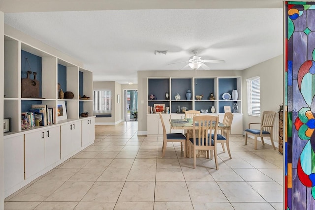 dining room featuring ceiling fan, a textured ceiling, and light tile patterned floors