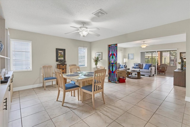 dining room featuring ceiling fan, a textured ceiling, and light tile patterned floors