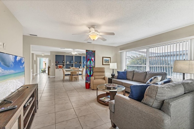 tiled living room with a textured ceiling and ceiling fan