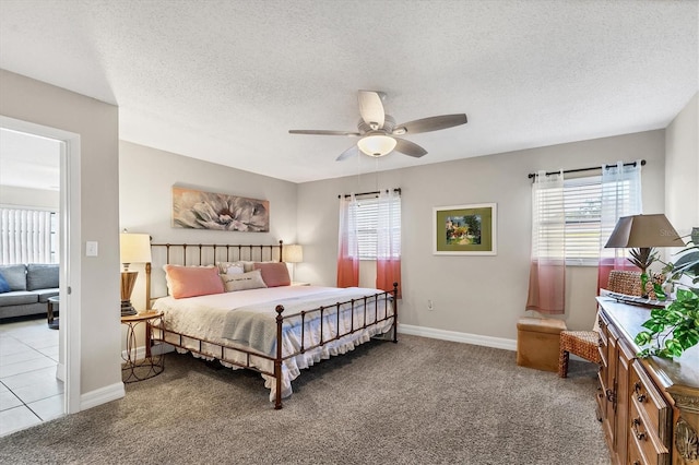 bedroom featuring a textured ceiling, ceiling fan, and light colored carpet