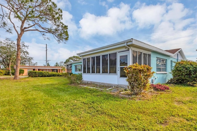 exterior space with a yard and a sunroom