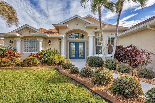 view of front of property featuring a front yard and french doors