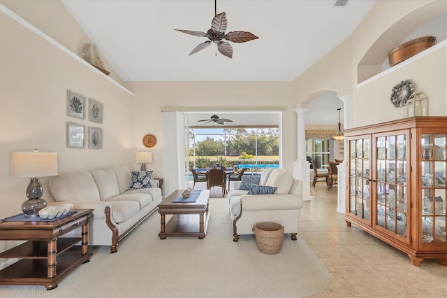 tiled living room with vaulted ceiling, decorative columns, and ceiling fan