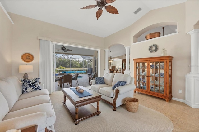 tiled living room with ornate columns, vaulted ceiling, and ceiling fan