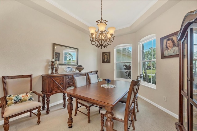 dining area with ornamental molding, light colored carpet, a raised ceiling, and a chandelier