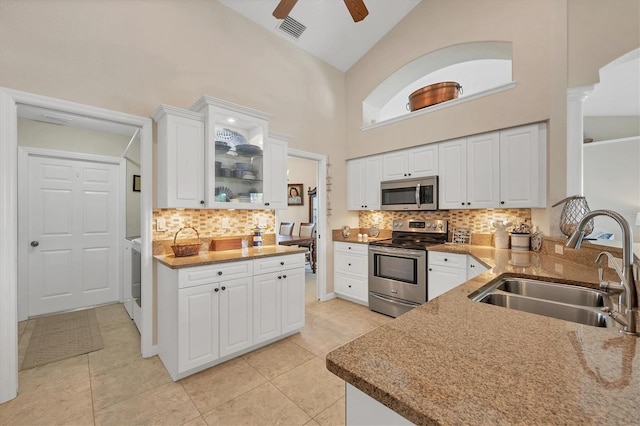 kitchen with sink, tasteful backsplash, high vaulted ceiling, appliances with stainless steel finishes, and white cabinets