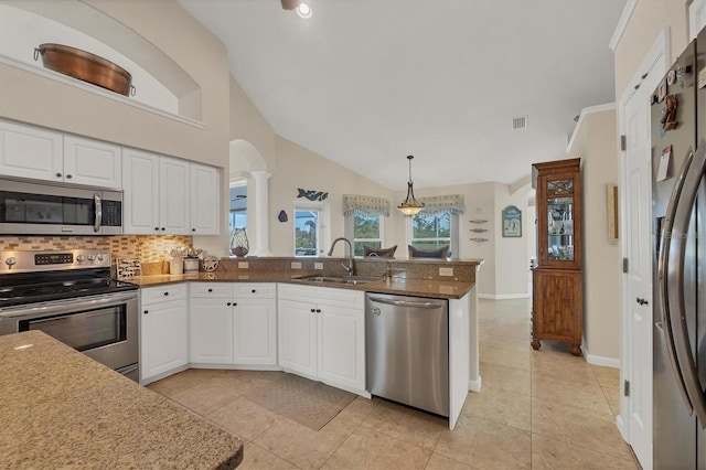 kitchen with white cabinetry, appliances with stainless steel finishes, vaulted ceiling, and sink