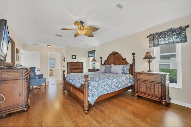 bedroom with hardwood / wood-style floors, ceiling fan, and ensuite bathroom