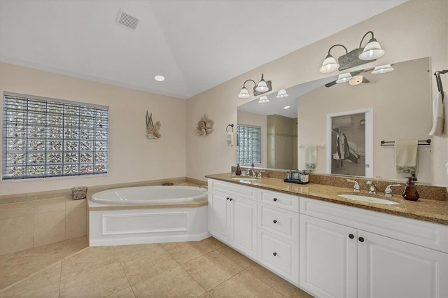 bathroom featuring vanity, tile patterned flooring, lofted ceiling, and a bathing tub