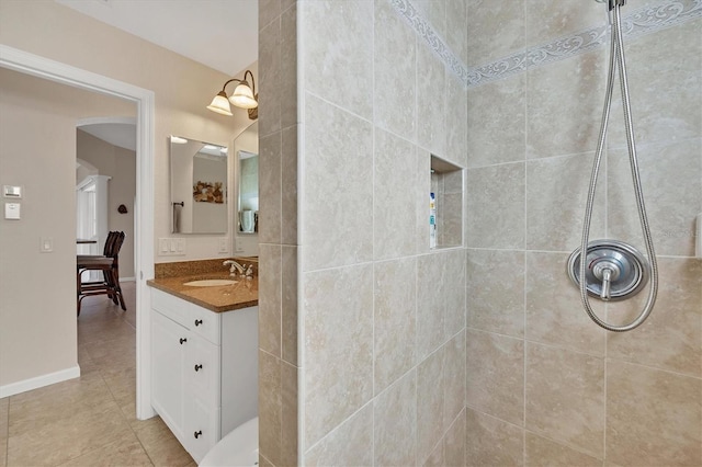 bathroom with vanity and a tile shower