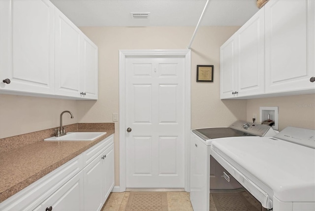 laundry room with sink, light tile patterned floors, washing machine and dryer, and cabinets