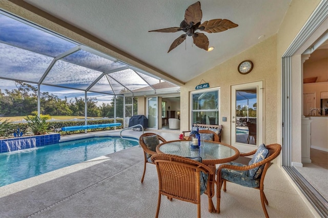 view of pool with pool water feature, area for grilling, glass enclosure, ceiling fan, and a patio