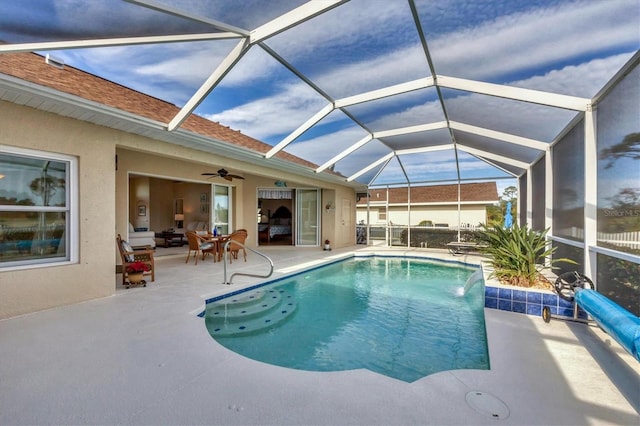 view of pool featuring a patio area, pool water feature, ceiling fan, and glass enclosure