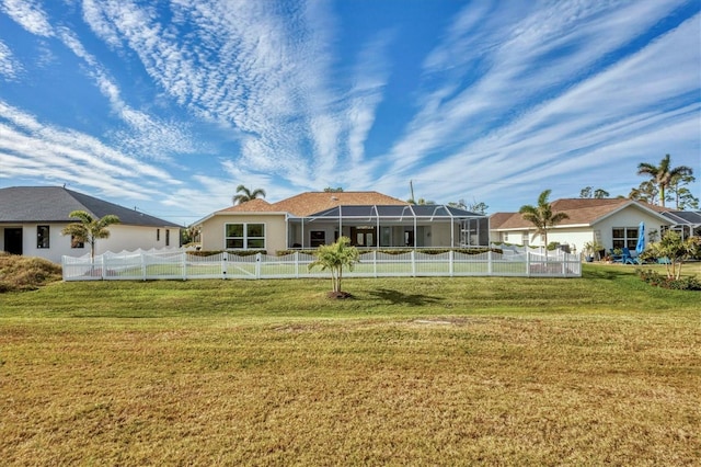 rear view of property with a lanai and a lawn