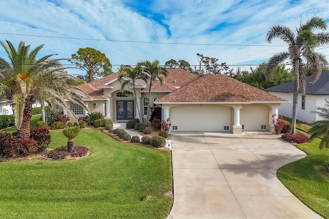 mediterranean / spanish-style house featuring a garage, a front yard, and french doors