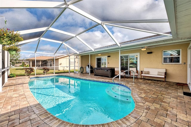 view of swimming pool with glass enclosure, a hot tub, ceiling fan, and a patio