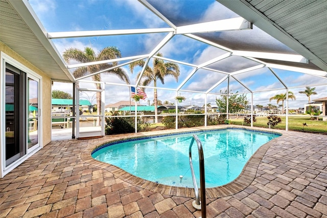 view of pool featuring glass enclosure and a patio