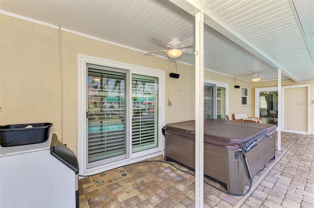 view of patio with ceiling fan and a hot tub