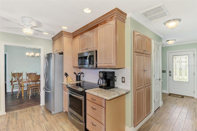 kitchen with decorative backsplash, appliances with stainless steel finishes, light stone counters, and light hardwood / wood-style flooring