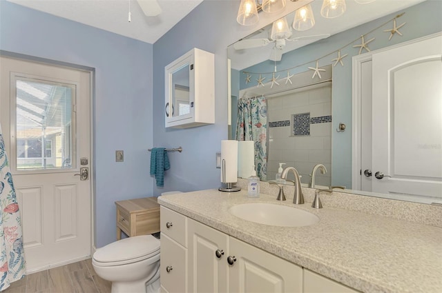 bathroom featuring toilet, hardwood / wood-style flooring, ceiling fan, a shower with shower curtain, and vanity