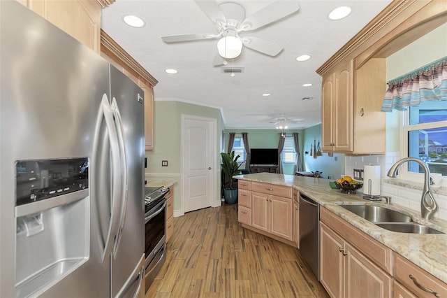 kitchen with kitchen peninsula, sink, crown molding, light brown cabinets, and stainless steel appliances